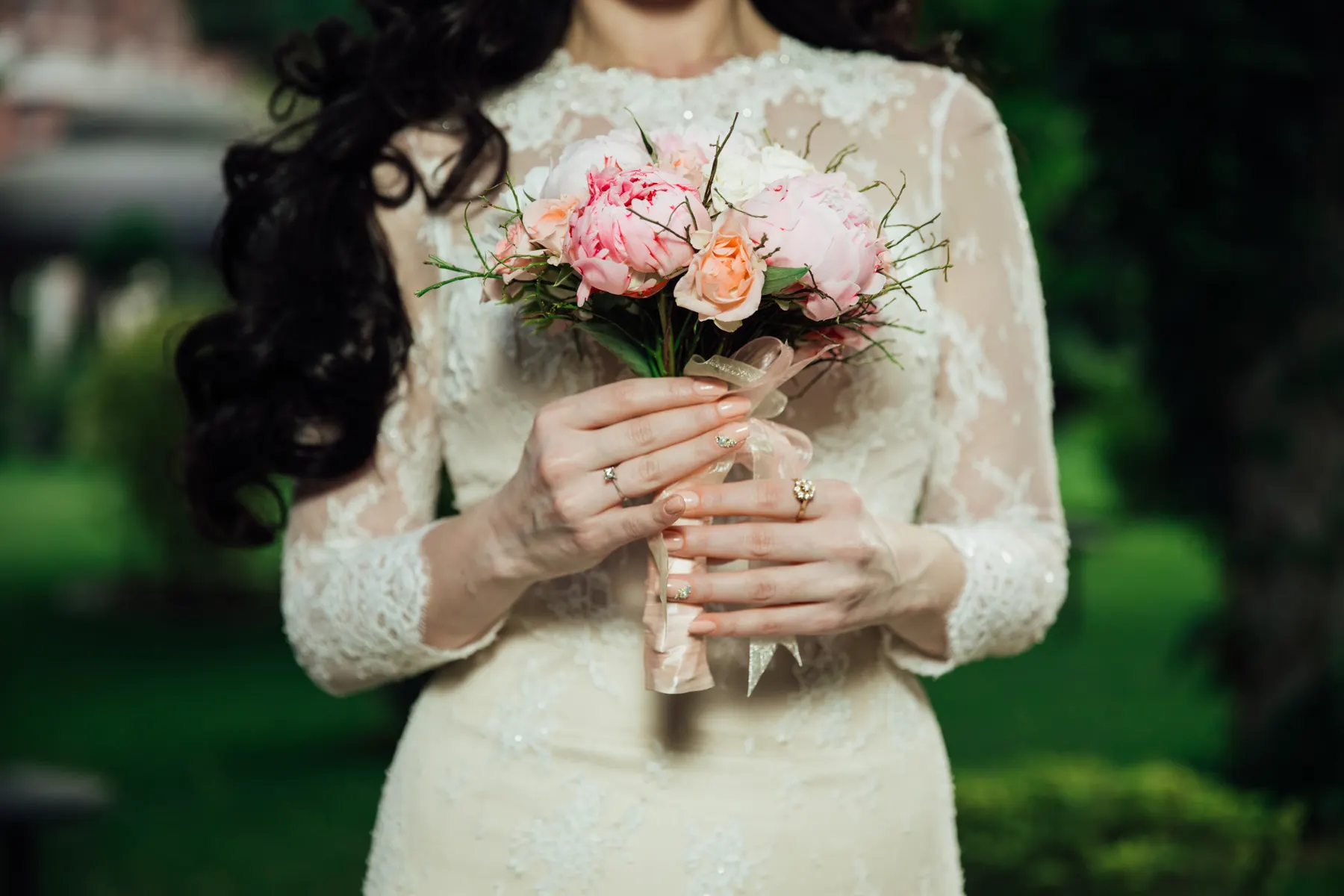 A bride holding a small blush and peach bridal bouquet